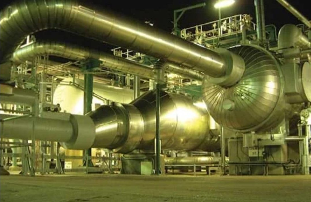 Hot-service vessels and clad piping on a plant at night